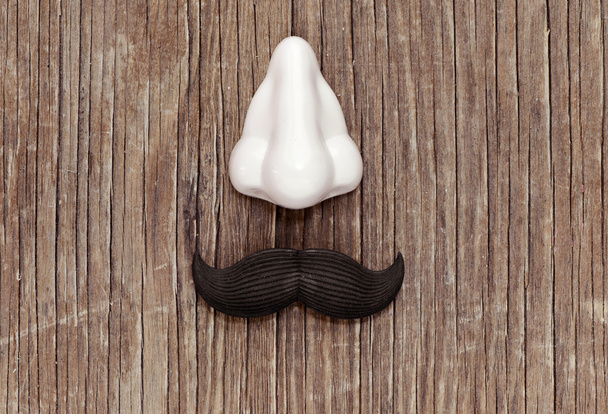 bigode falso e nariz em uma superfície de madeira
 - Foto, Imagem