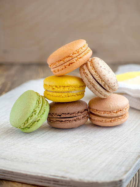 colored macaroon on a wooden background - 写真・画像