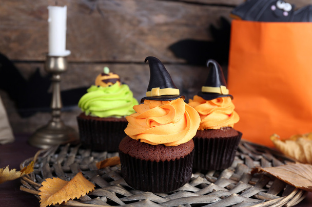 Halloween cupcakes on wicker mat on table - 写真・画像