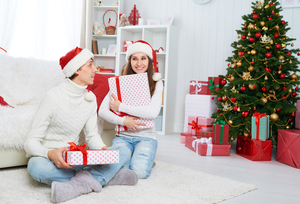 happy family couple with a gift on Christmas at home - Foto, Imagem