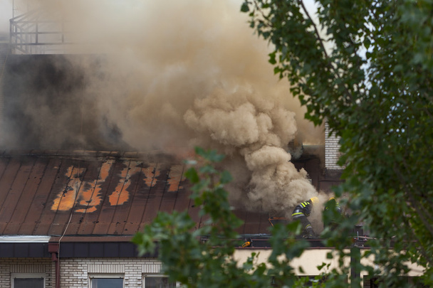 Ομάδα πυροσβεστών στην εργασία στη στέγη σε πραγματική κατάσταση - Φωτογραφία, εικόνα