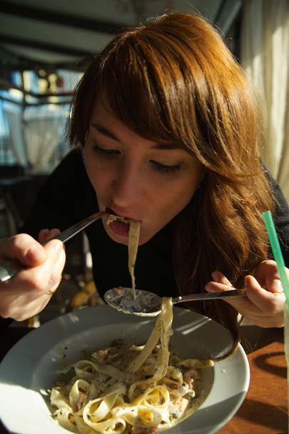 Nainen syö spagettia ravintolassa
 - Valokuva, kuva