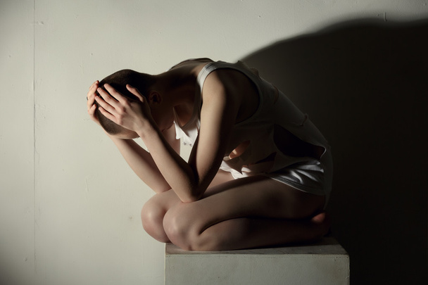 Mental illness. Shot of thin girl holding her head - Foto, Imagen
