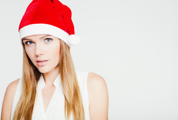 Portrait of beautiful young woman wearing santa claus hat - Photo, Image