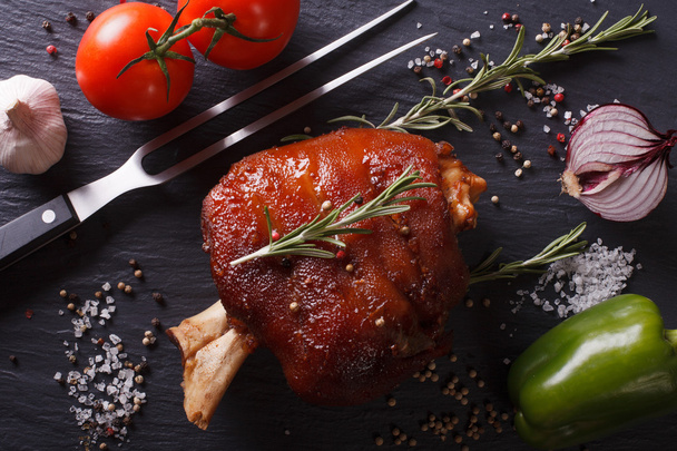 Gebakken varkensvlees knokkel, groenten en kruiden close-up. Horizontale t - Foto, afbeelding