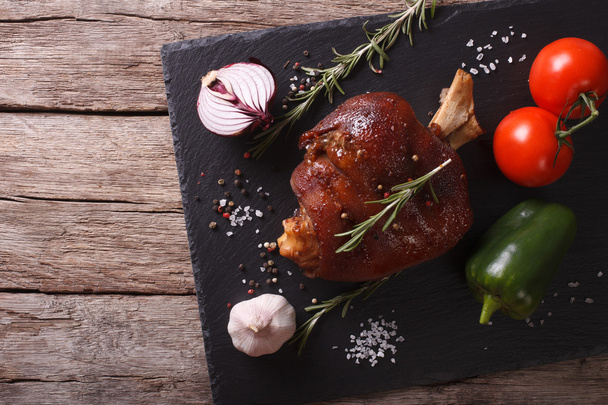 Baked pork shank and vegetables on a slate board. horizontal top - Photo, Image