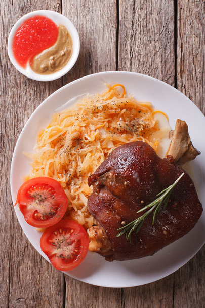 pork shank, sauerkraut and sauce closeup. vertical top view - Photo, Image