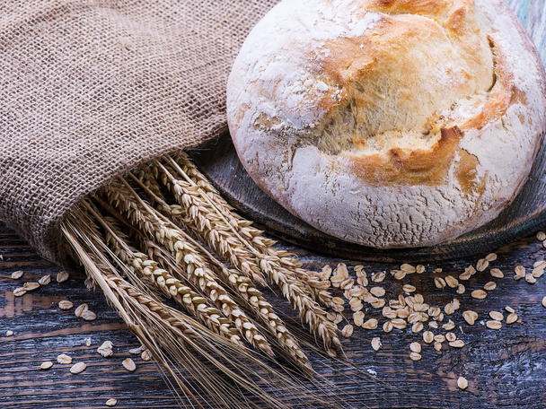 Fehér sült kenyér, egy fából készült háttér - Fotó, kép
