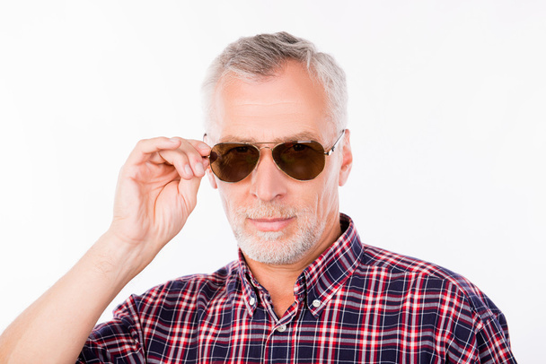 Gray confident aged man holding his sunglasses - Foto, Imagen