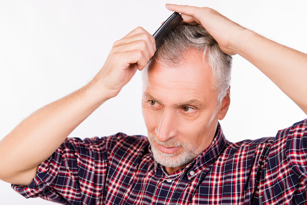 Handsome gray aged man combing hair - Foto, Imagem
