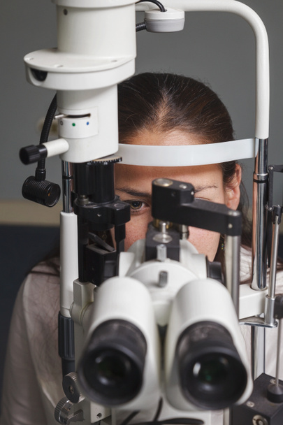 Bella giovane donna che ha un esame oculistico dall'optometrista - Foto, immagini