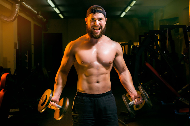 man in gym training with dumbbells - Photo, Image