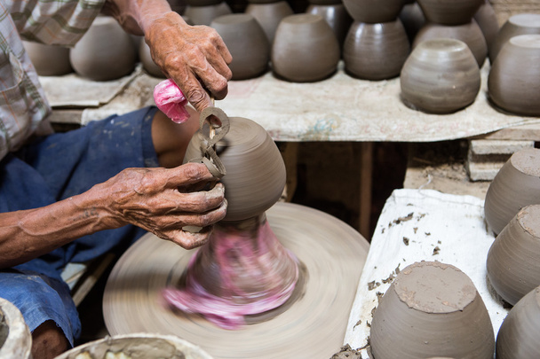 грязные руки делают керамику из глины на колесах
 - Фото, изображение