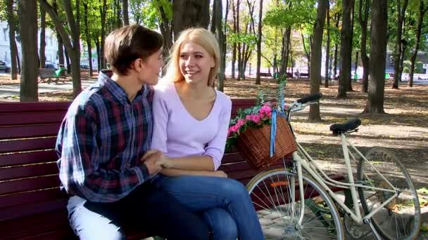 Paar mit Retro-Fahrrad im Park auf Bank. - Filmmaterial, Video