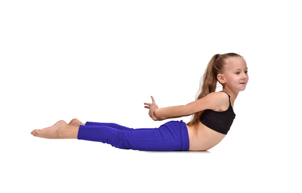 girl in blue clothing doing yoga exercises on a white background - Fotó, kép