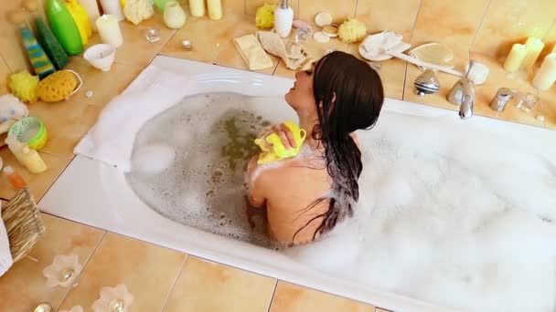 バブルお風呂を取る若い女性。トップ ビュー. - 映像、動画