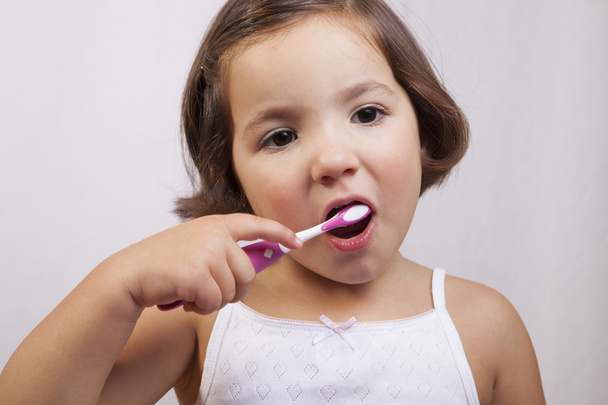 Little brown eye girl brushing her teeth - Valokuva, kuva