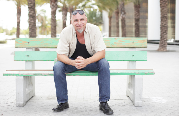 muž sedící na lavičce autobusové zastávky - Fotografie, Obrázek