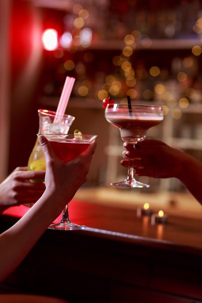 Raising glass in cocktail bar - Zdjęcie, obraz