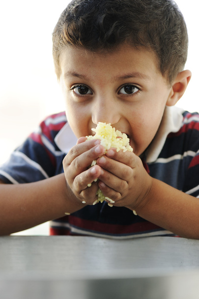 Портрет бідності, маленький бідний хлопчик на харчовому горщику, що їсть рис
 - Фото, зображення