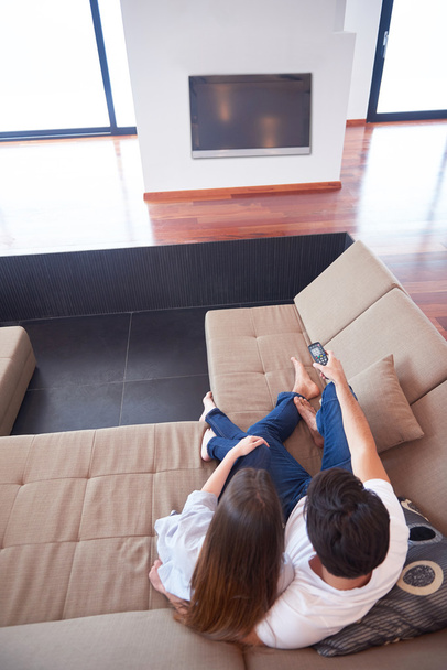 νεαρό ζευγάρι που βλέπει τηλεόραση στο σπίτι - Φωτογραφία, εικόνα