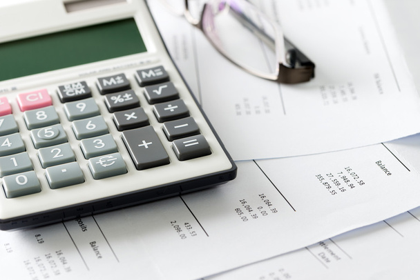 Financial statement with calculator and glasses - Photo, Image