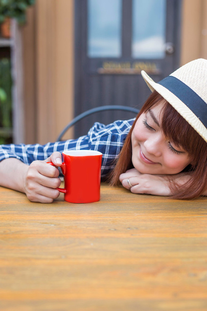 usar chapéu mulher sentado ao ar livre com bebida quente relaxar
 - Foto, Imagem