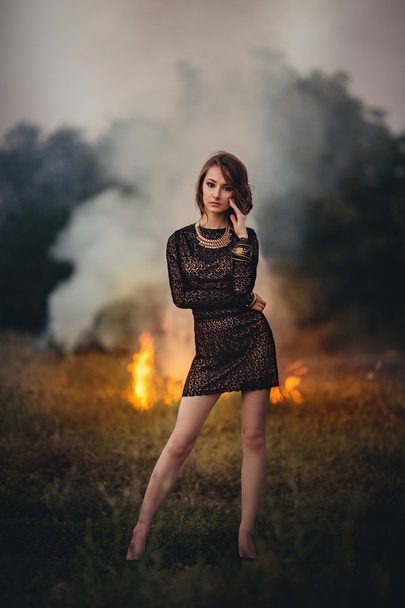 dívka stojí na pozadí hořícího ohně - Fotografie, Obrázek