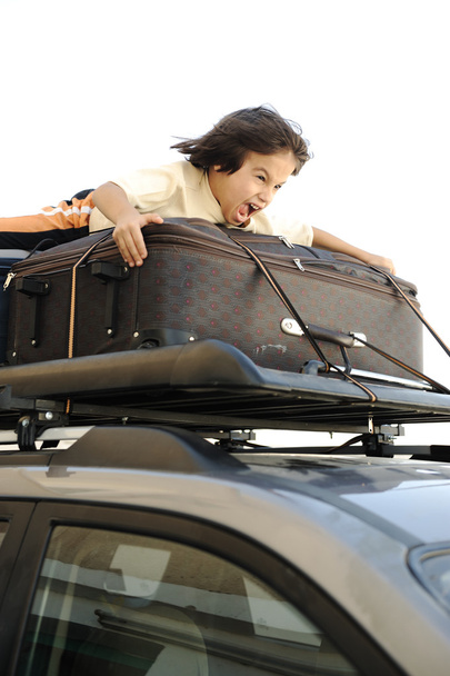 Little boy traveling on bags, the top of the car - 写真・画像