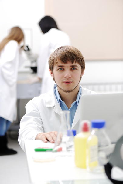 Young medical scientist working in modern lab, research with tubes and note - Valokuva, kuva