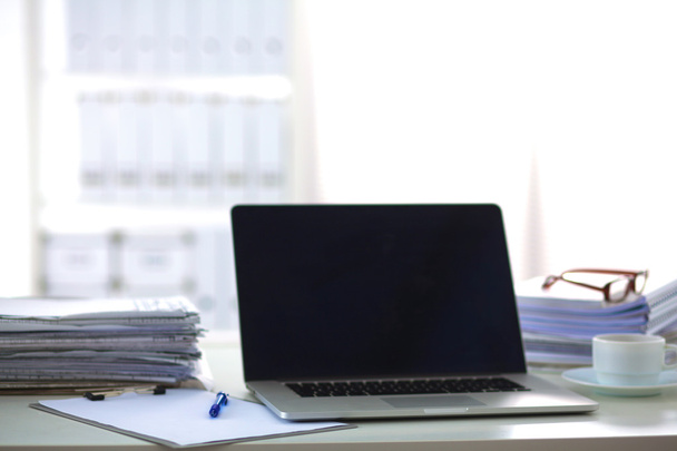 Ноутбук со стопкой папок на белом фоне - Фото, изображение