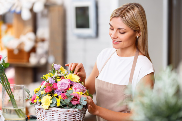 Professional florist working in a flower shop - Foto, afbeelding