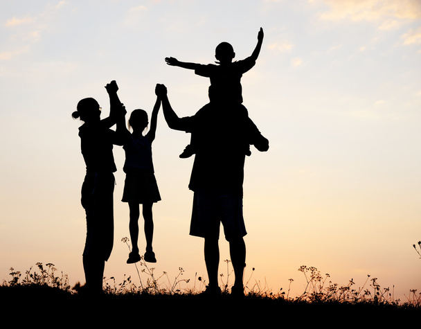 Silhouette, happy children with mother and father, family at sunset, summer - Foto, afbeelding