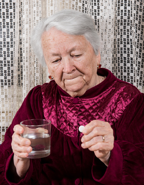 Стара жінка збирається прийняти ліки
 - Фото, зображення