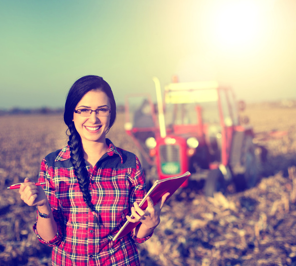 Женщина с трактором на поле
 - Фото, изображение