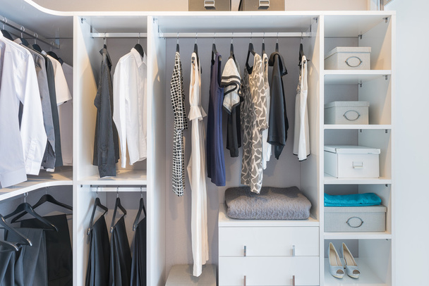 Одяг, що висить на рейці в білому гардеробі
 - Фото, зображення