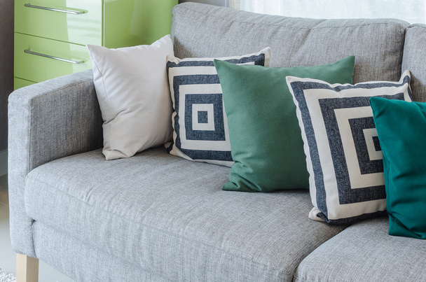 современный серый диван с черно-белыми и зелеными подушками
 - Фото, изображение