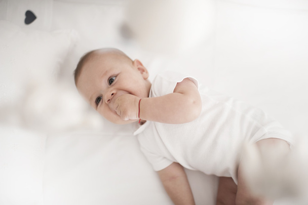 Söpö poikavauva leikkii ja nauraa sängyssä
 - Valokuva, kuva