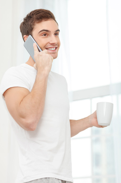 Cheerful young guy is enjoying hot drink - Photo, Image