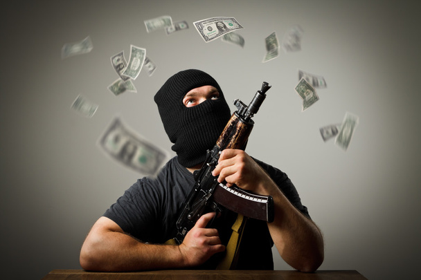 Man with gun and dollar banknotes. - Фото, зображення
