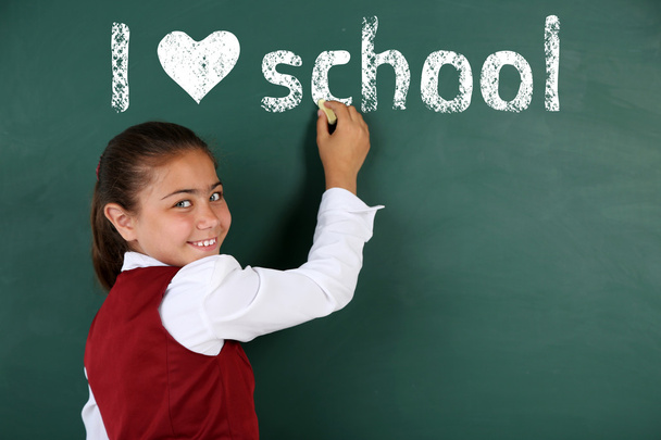 Cheerful girl at the blackboard. I love learning concept - Photo, Image