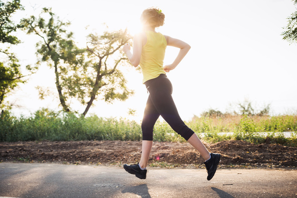 Running woman. Female runner jogging during the sunrise - Foto, imagen