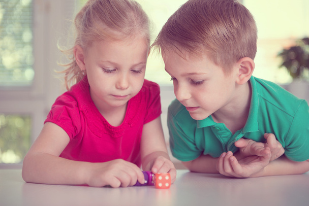 Two happy children playing with dices - Foto, imagen