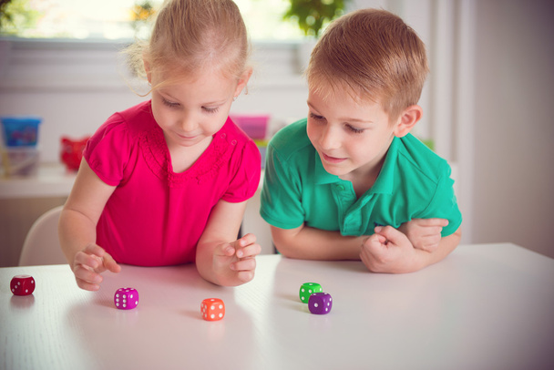 Two happy children playing with dices - Foto, Imagem