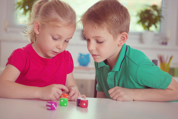 Two happy children playing with dices - Фото, зображення