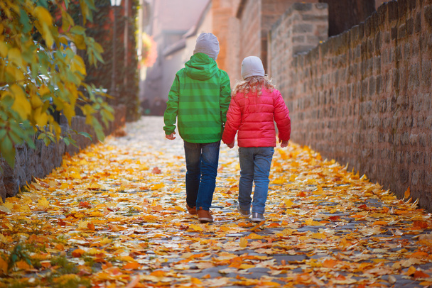Cute children walking in autumn town - Foto, imagen