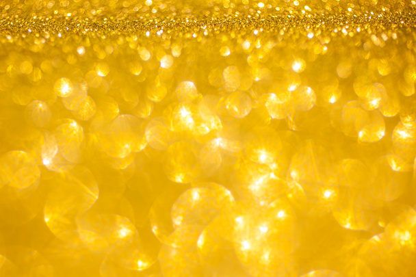 Gouden glitter Kerstmis abstracte achtergrond. Glanzende gouden lichten - Foto, afbeelding