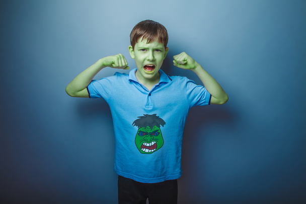 Зелений супергерой хлопчик-підліток підняв руку кричачи шкіру міцності
 - Фото, зображення