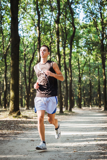 young caucasian male running in park. Teenager jogging in park - Foto, Imagem