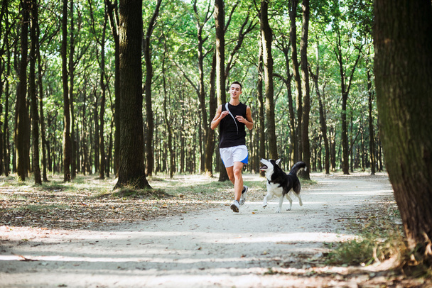 work out with dog. Young caucasian male running with siberian hu - Fotoğraf, Görsel